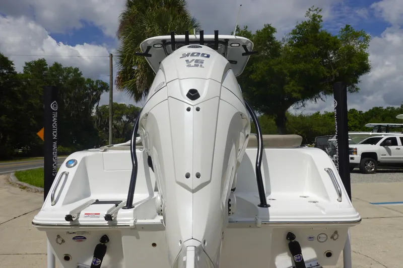 Slide: The Image of 2026 Sea Hunt Ultra 245 SE boat with powerful outboard motor, parked outdoors. - 5