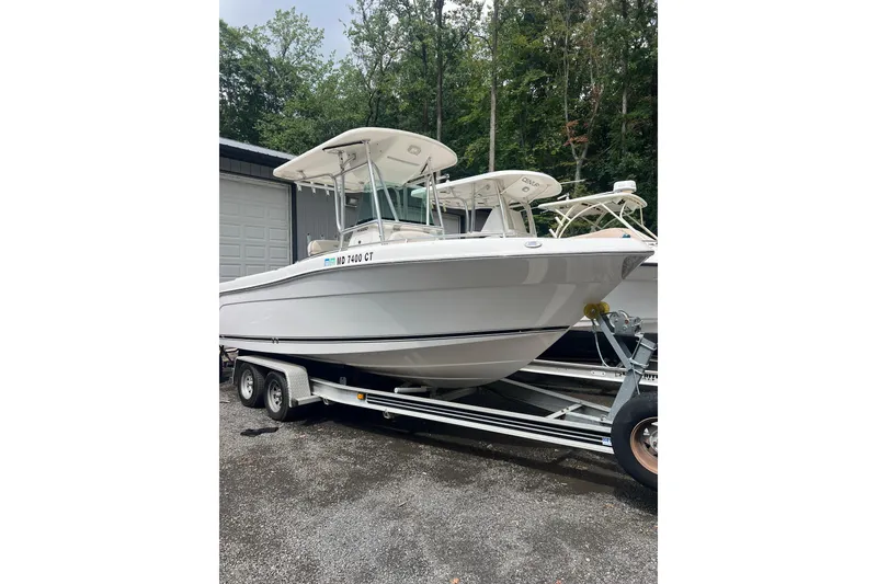The Image of 2005 Robalo R220 Center Console boat on trailer, parked outdoors. - 0
