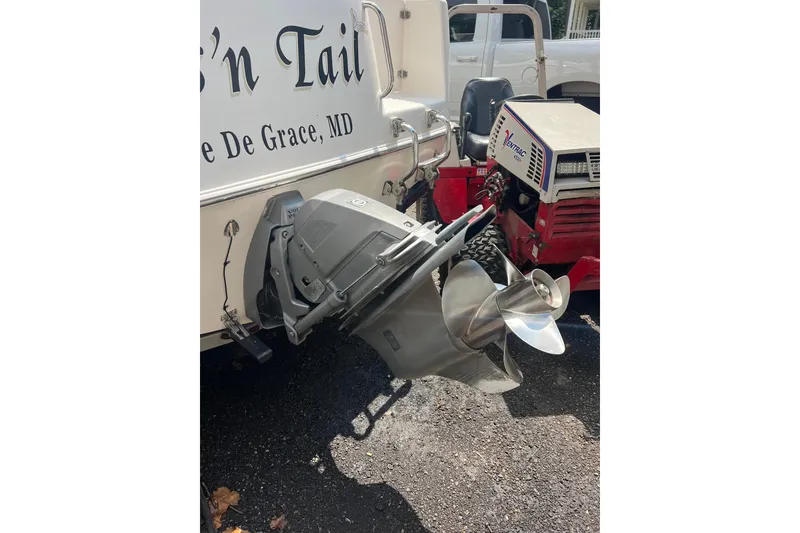 Slide: The Image of 2005 Robalo R220 Center Console boat with outboard motor and propeller, parked on asphalt. - 5