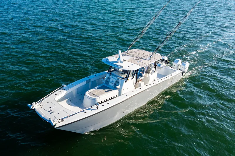 Slide: The Image of 2022 Freeman 42LR boat cruising on open water, equipped with fishing rods and twin engines. - 10