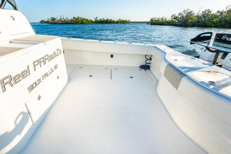 Slide: The Image of Freeman 42LR 2022 boat deck with scenic water view and lush greenery. - 20