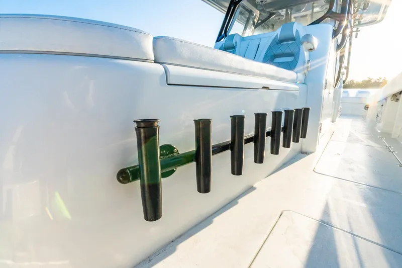 Slide: The Image of 2022 Freeman 42LR boat interior with rod holders and seating in sunlight. - 45