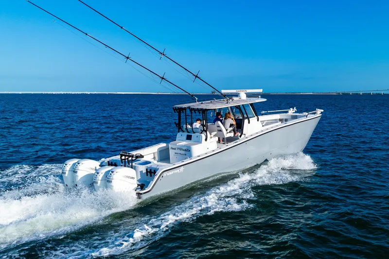Slide: The Image of 2022 Freeman 42LR boat cruising on open water with multiple outboard engines. - 5