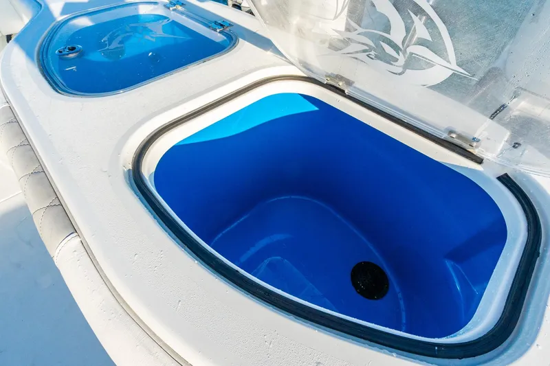 Slide: The Image of Open livewell on 2022 Freeman 42LR boat, featuring blue interior and transparent lid. - 54