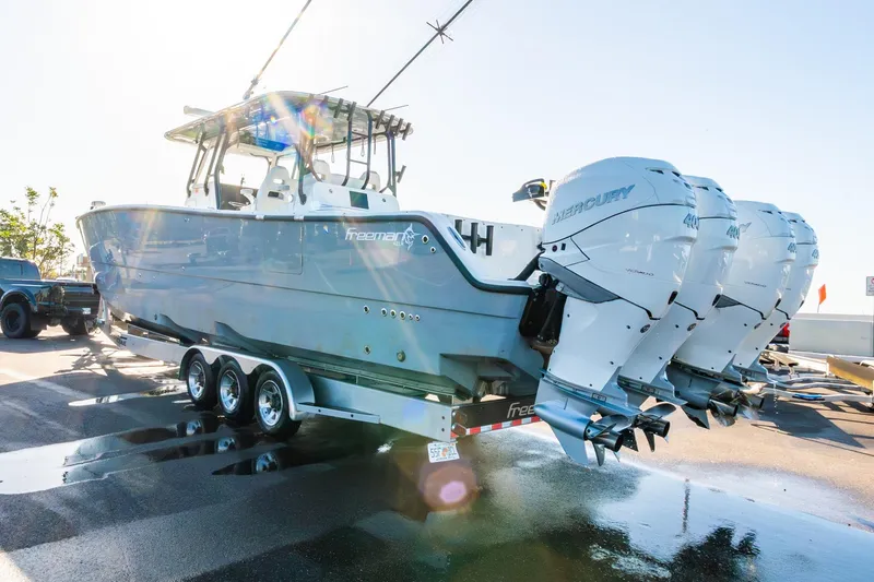 Slide: The Image of 2022 Freeman 42LR boat with four Mercury engines on a trailer in sunlight. - 67