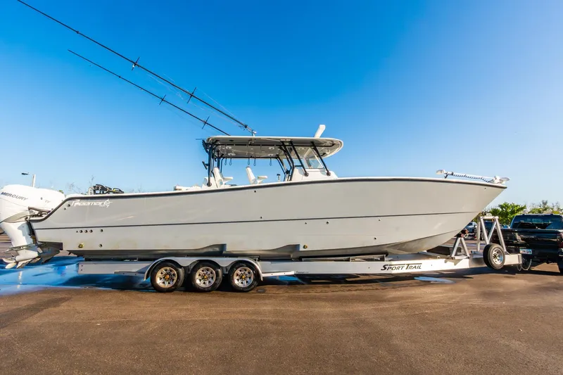 Slide: The Image of 2022 Freeman 42LR boat on trailer, side view, clear blue sky background. - 70