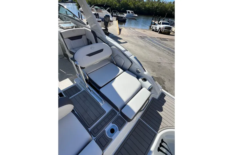 Slide: The Image of 2026 Crownline 310 XSS boat interior with luxurious seating at a marina. - 12