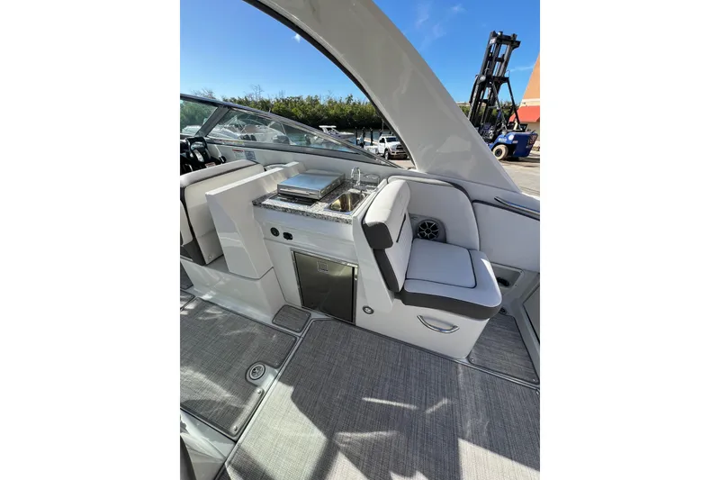 Slide: The Image of Interior of 2026 Crownline 310 XSS boat featuring seating and kitchenette area. - 17