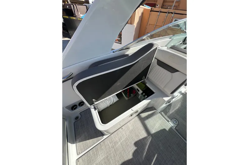 Slide: The Image of 2026 Crownline 310 XSS boat interior storage compartment open, revealing contents. - 18
