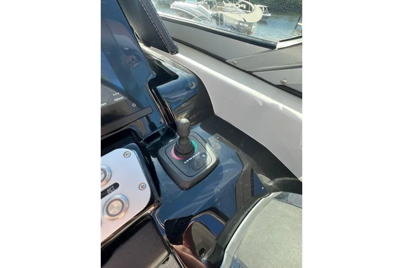 Slide: The Image of 2026 Crownline 310 XSS boat dashboard with joystick control and navigation display. - 25