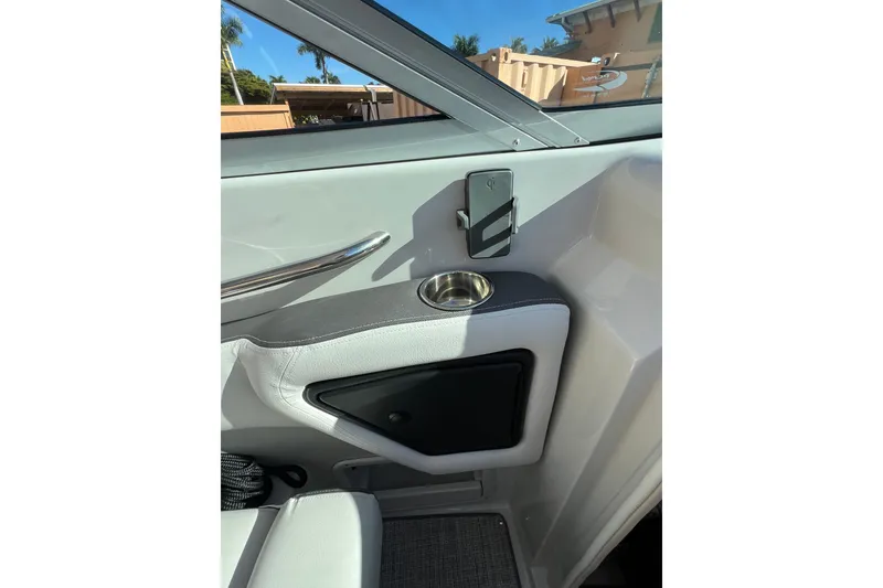 Slide: The Image of Interior of 2026 Crownline 310 XSS boat, featuring cup holder and sleek design. - 27