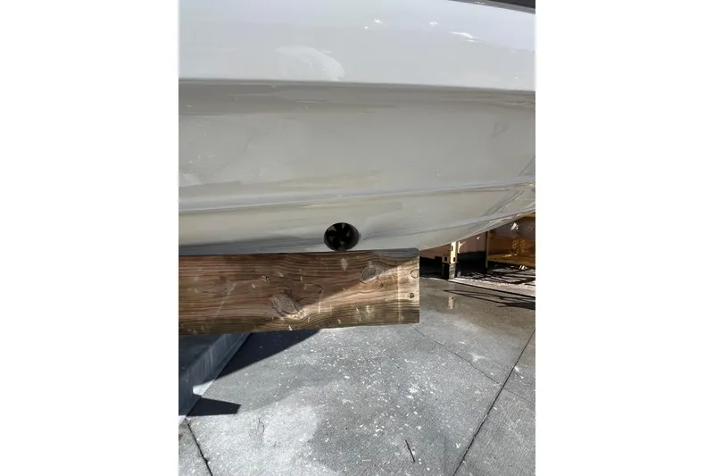 Slide: The Image of 2026 Crownline 310 XSS boat hull on wooden support, showcasing sleek design. - 3