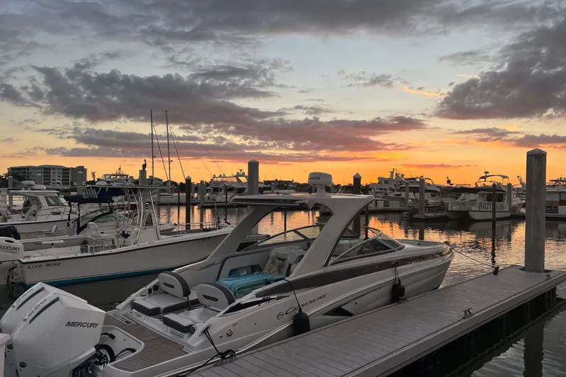 Slide: The Image of 2026 Crownline 310 XSS boat docked at sunset, serene marina view. - 33