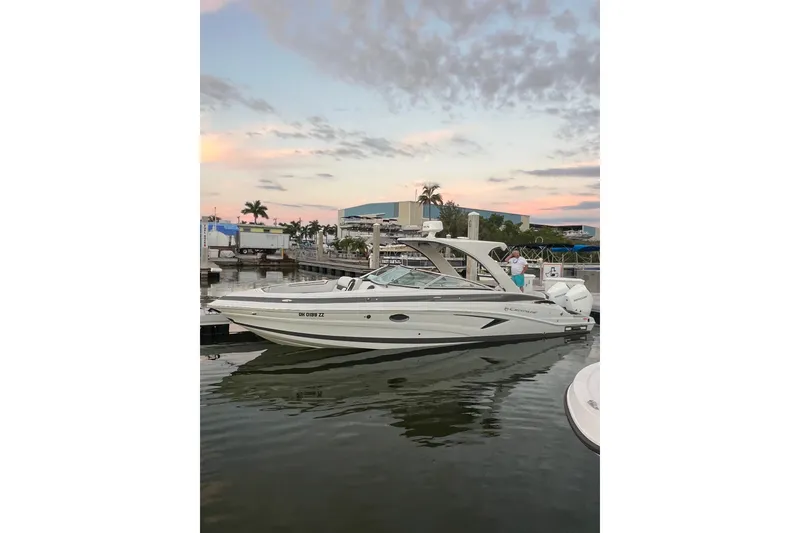 Slide: The Image of 2026 Crownline 310 XSS boat docked at marina during sunset. - 35