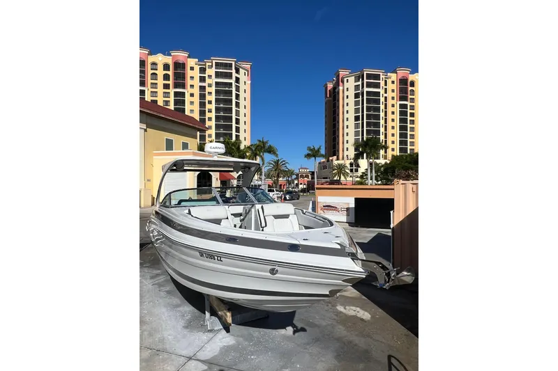 Slide: The Image of 2026 Crownline 310 XSS boat displayed near modern high-rise buildings. - 4