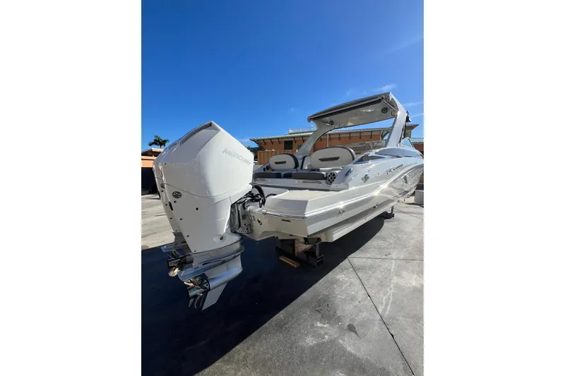 Slide: The Image of 2026 Crownline 310 XSS boat with Mercury engine, docked under clear blue sky. - 5