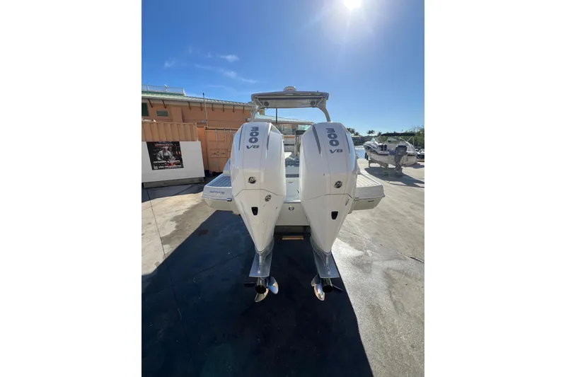 Slide: The Image of 2026 Crownline 310 XSS boat with dual 300 V8 engines, docked under clear blue sky. - 6