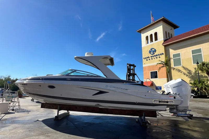 Slide: The Image of 2026 Crownline 310 XSS boat displayed at Cape Harbour Marina under clear blue sky. - 7