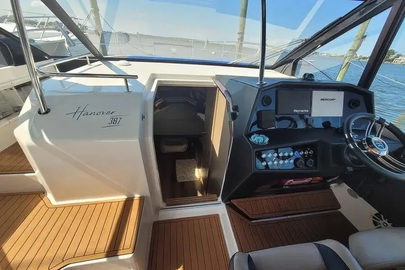 Slide: The Image of 2024 Hanover 387 boat interior with modern dashboard and wooden flooring. - 13