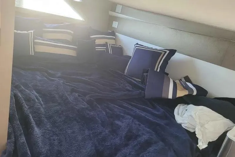 Slide: The Image of Cozy bed with blue and striped pillows in a 2024 Hanover 387 interior. - 14