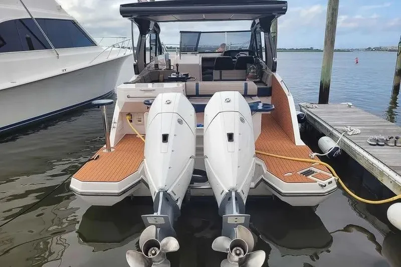 Slide: The Image of 2024 Hanover 387 boat with dual outboard motors docked at marina. - 17