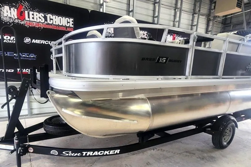 Slide: The Image of 2026 Sun Tracker Bass Buggy 16 XL Select pontoon boat on trailer in showroom. - 8