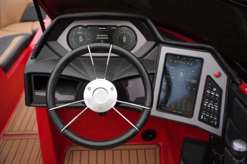 Slide: The Image of Steering wheel and dashboard of 2022 MasterCraft XStar S boat, featuring digital displays. - 11