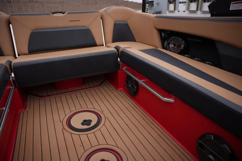 Slide: The Image of 2022 MasterCraft XStar S interior with tan and black seating, red accents, and premium audio system. - 13