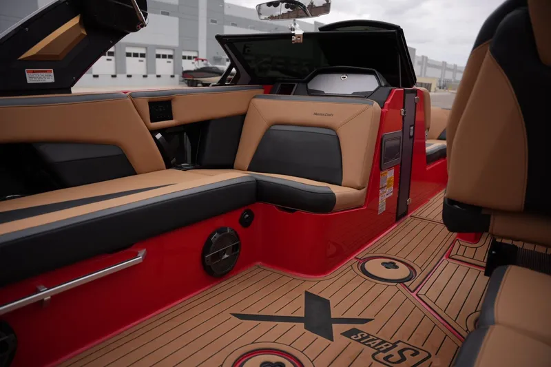 Slide: The Image of Interior of 2022 MasterCraft XStar S boat with tan and black seating, red accents. - 16