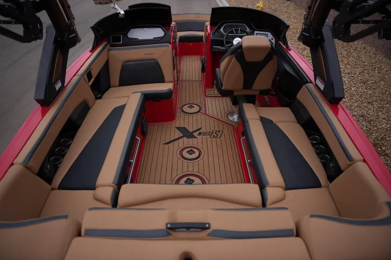 Slide: The Image of 2022 MasterCraft XStar S boat interior with tan and black seating, red accents. - 18