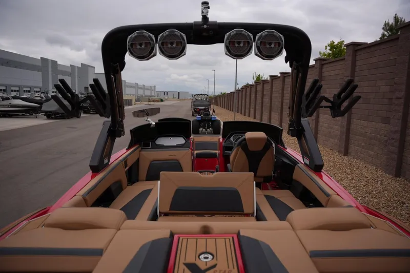 Slide: The Image of 2022 MasterCraft XStar S boat interior with tan seating and wakeboard racks. - 19