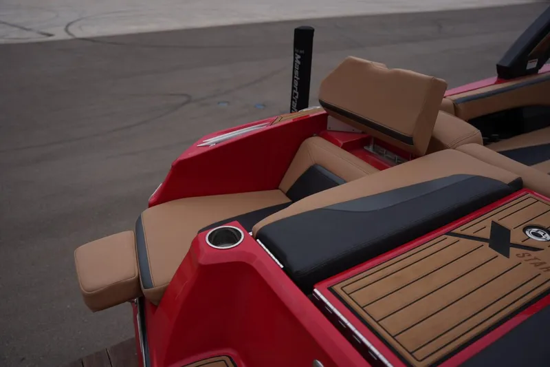 Slide: The Image of 2022 MasterCraft XStar S boat interior with tan and black seating, red accents. - 20