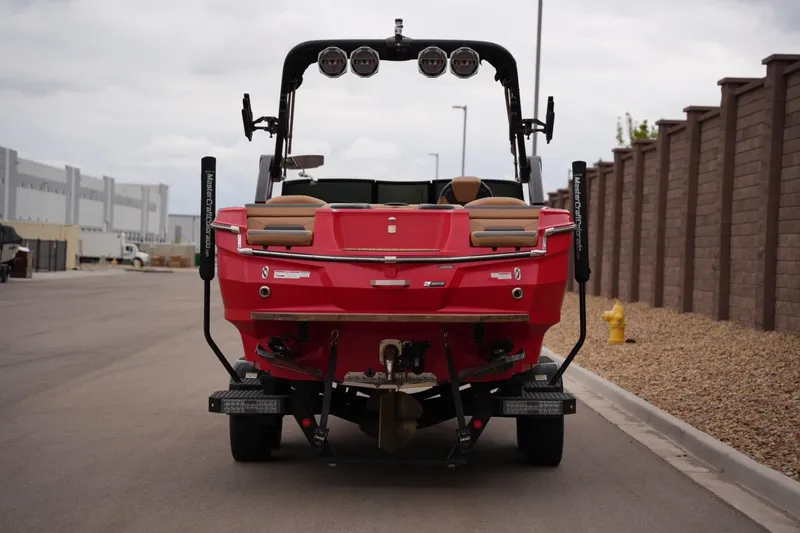 Slide: The Image of 2022 MasterCraft XStar S boat, red, rear view on trailer, urban setting. - 3