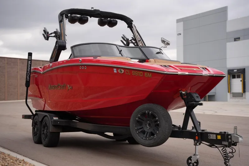 Slide: The Image of 2022 MasterCraft XStar S boat on trailer, vibrant red, parked outdoors. - 6