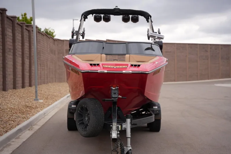Slide: The Image of 2022 MasterCraft XStar S boat on trailer, parked on a paved road. - 7