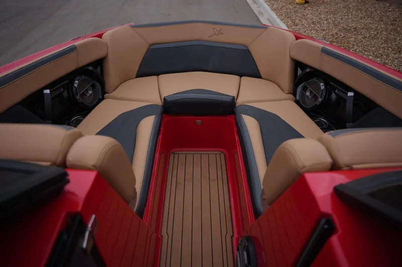 Slide: The Image of 2022 MasterCraft XStar S boat interior with tan and black seating, red accents, and premium speakers. - 8