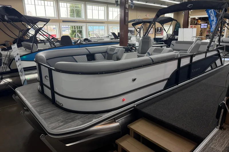 The Image of 2026 Crest Conquest 250 SLSC pontoon boat displayed in a showroom setting. - 1