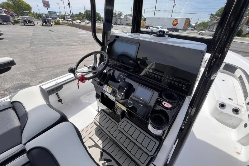 Slide: The Image of 2026 Tidewater 2300 Carolina Bay boat dashboard with steering wheel and electronic controls. - 7
