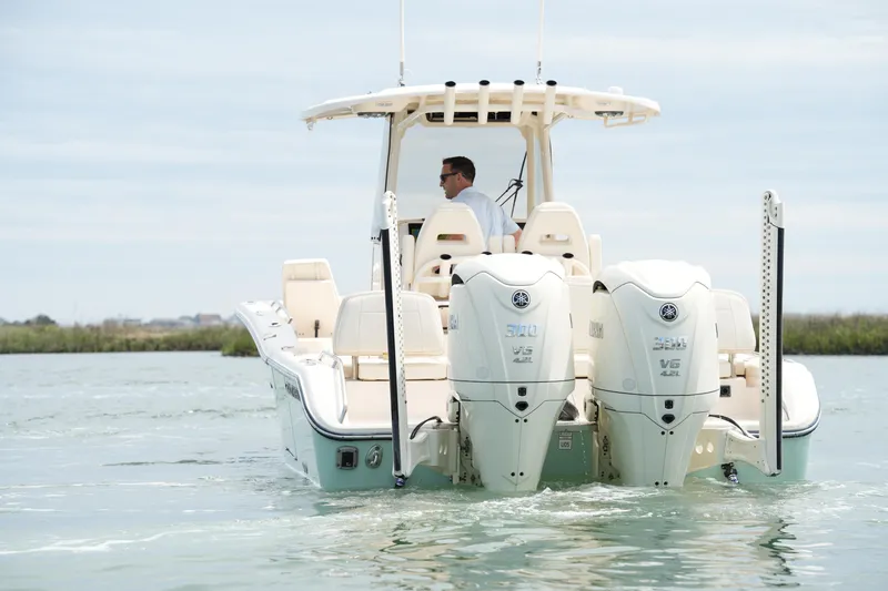 Slide: The Image of 2024 Grady-White 281 Coastal Explorer boat with dual Yamaha engines on calm water. - 11