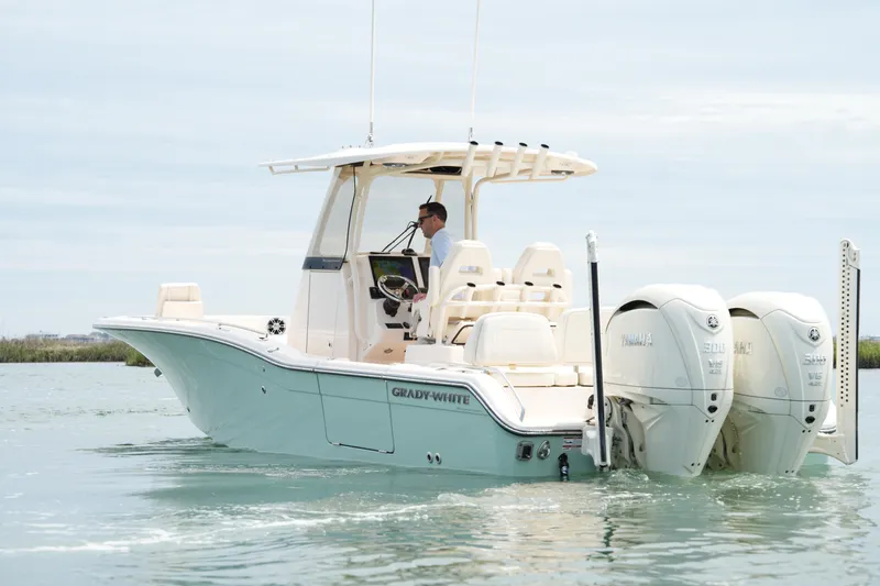 Slide: The Image of 2024 Grady-White 281 Coastal Explorer boat cruising on calm waters with dual Yamaha engines. - 13