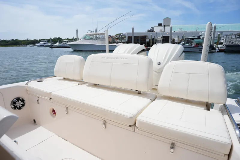 Slide: The Image of 2024 Grady-White 281 Coastal Explorer boat interior with white seating at marina. - 16