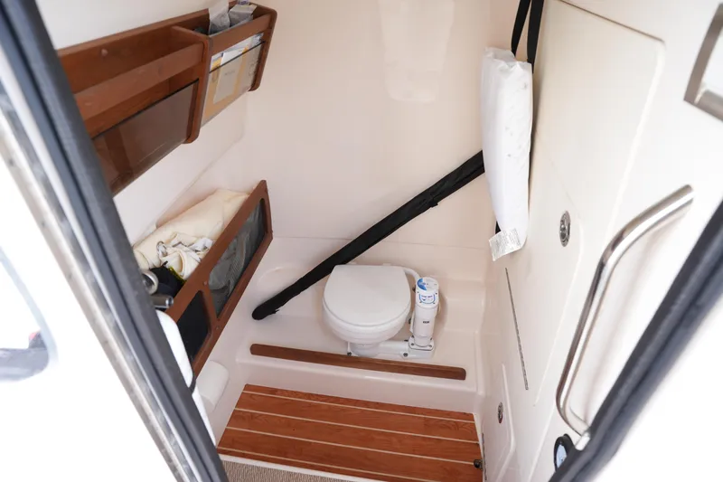 Slide: The Image of 2024 Grady-White 281 Coastal Explorer boat interior with compact marine toilet. - 31