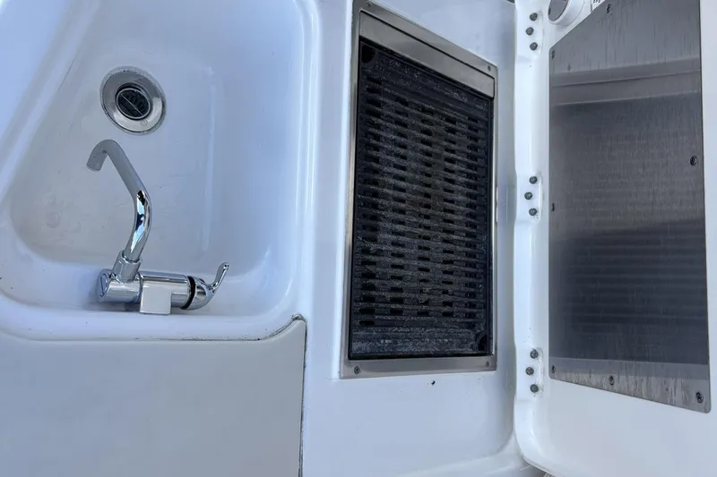 Slide: The Image of 2020 Pursuit DC 365 Dual Console boat sink and grill area. - 11
