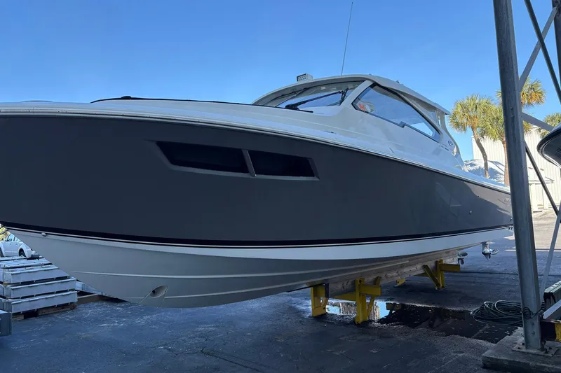 Slide: The Image of 2020 Pursuit DC 365 Dual Console boat on dry dock, side view. - 17