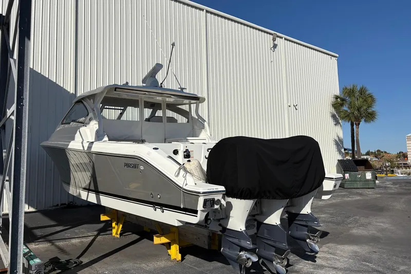 Slide: The Image of 2020 Pursuit DC 365 Dual Console boat on dry dock, with covered engines. - 22