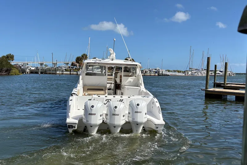 Slide: The Image of 2020 Pursuit DC 365 Dual Console boat with triple engines on water. - 3