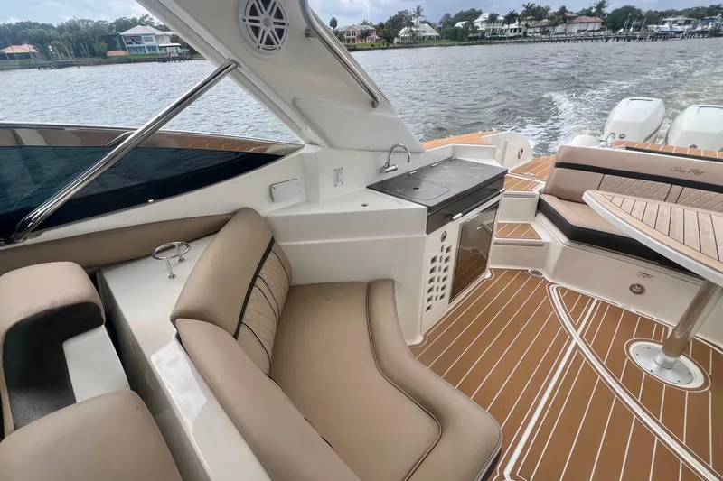 Slide: The Image of Luxurious 2017 Sea Ray SLX 350 Outboard interior with seating, table, and kitchenette on water. - 14