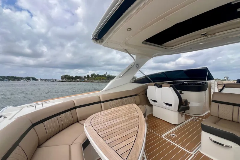 Slide: The Image of 2017 Sea Ray SLX 350 Outboard boat interior with luxurious seating and wooden table. - 16