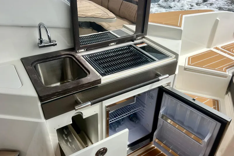 Slide: The Image of Outdoor kitchen on 2017 Sea Ray SLX 350 Outboard with sink, grill, and fridge. - 20