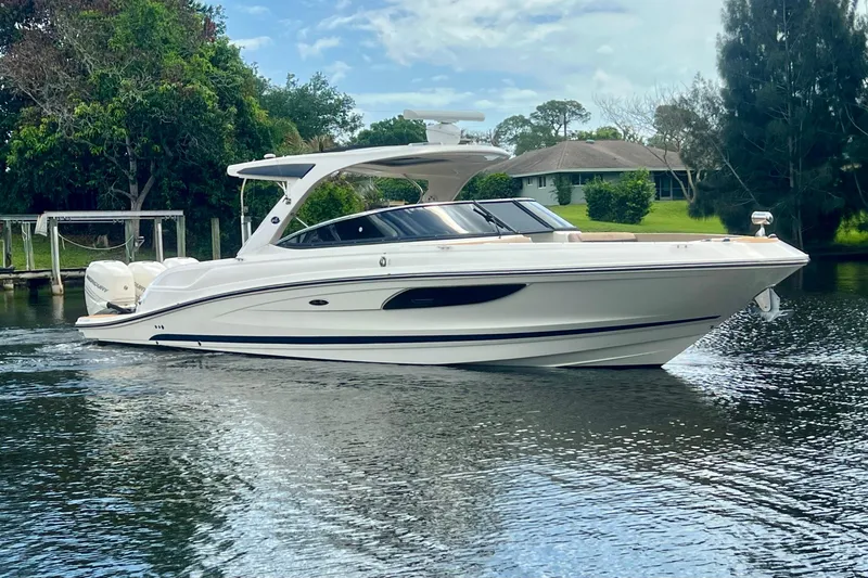 Slide: The Image of 2017 Sea Ray SLX 350 Outboard cruising on a serene waterway, surrounded by lush greenery. - 3